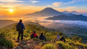 Pendaki menikmati panorama pegunungan dan hamparan awan saat matahari terbit dari kawasan wisata alam.